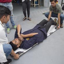 Estudiantes del CUAAD, probando una camilla de rescate fabricada.