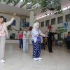 Adultos mayores realizando actividad física para mejorar su calidad de vida, en el patio de una institución pública.