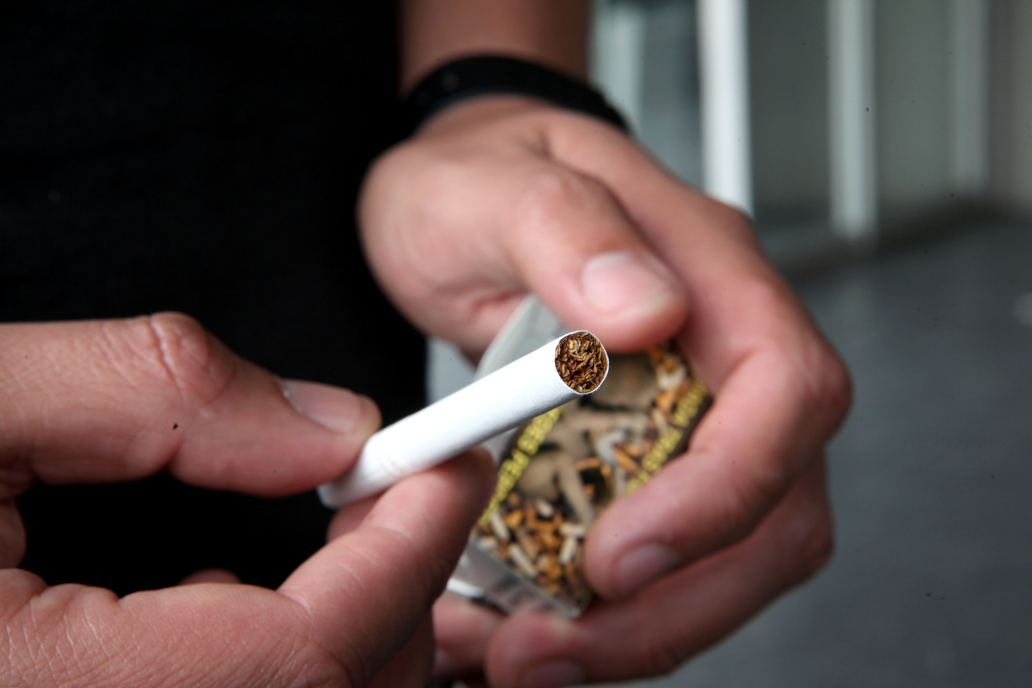 Manos de hombre sosteniendo un cigarro